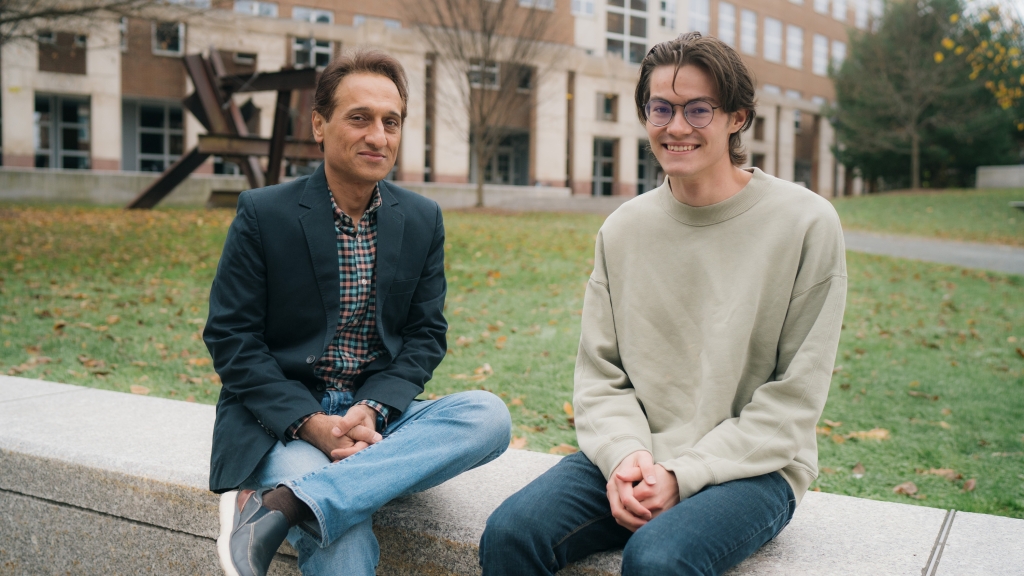 Alireza Soltani, associate professor of psychological and brain sciences, and Ethan Trepka '22 sit on a wall together