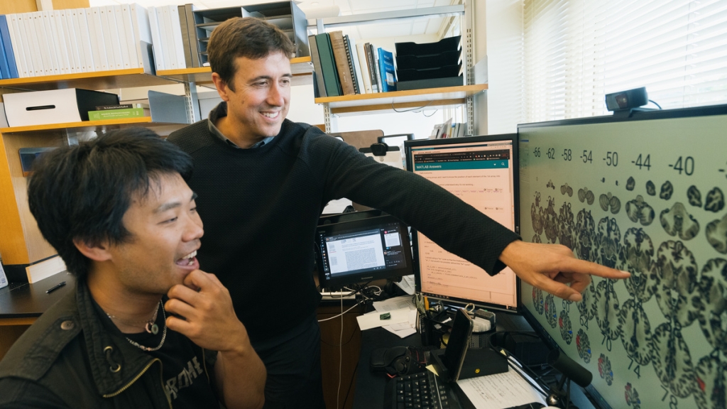 Michael Sun and Tor Wager looking at a computer
